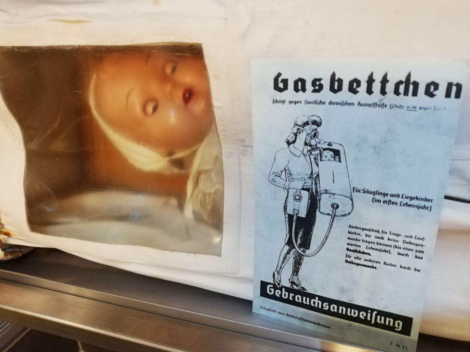 Ausstellungsstück Gasbettchen mit Puppe drinnen und der Gebrauchsanweisung dafür   