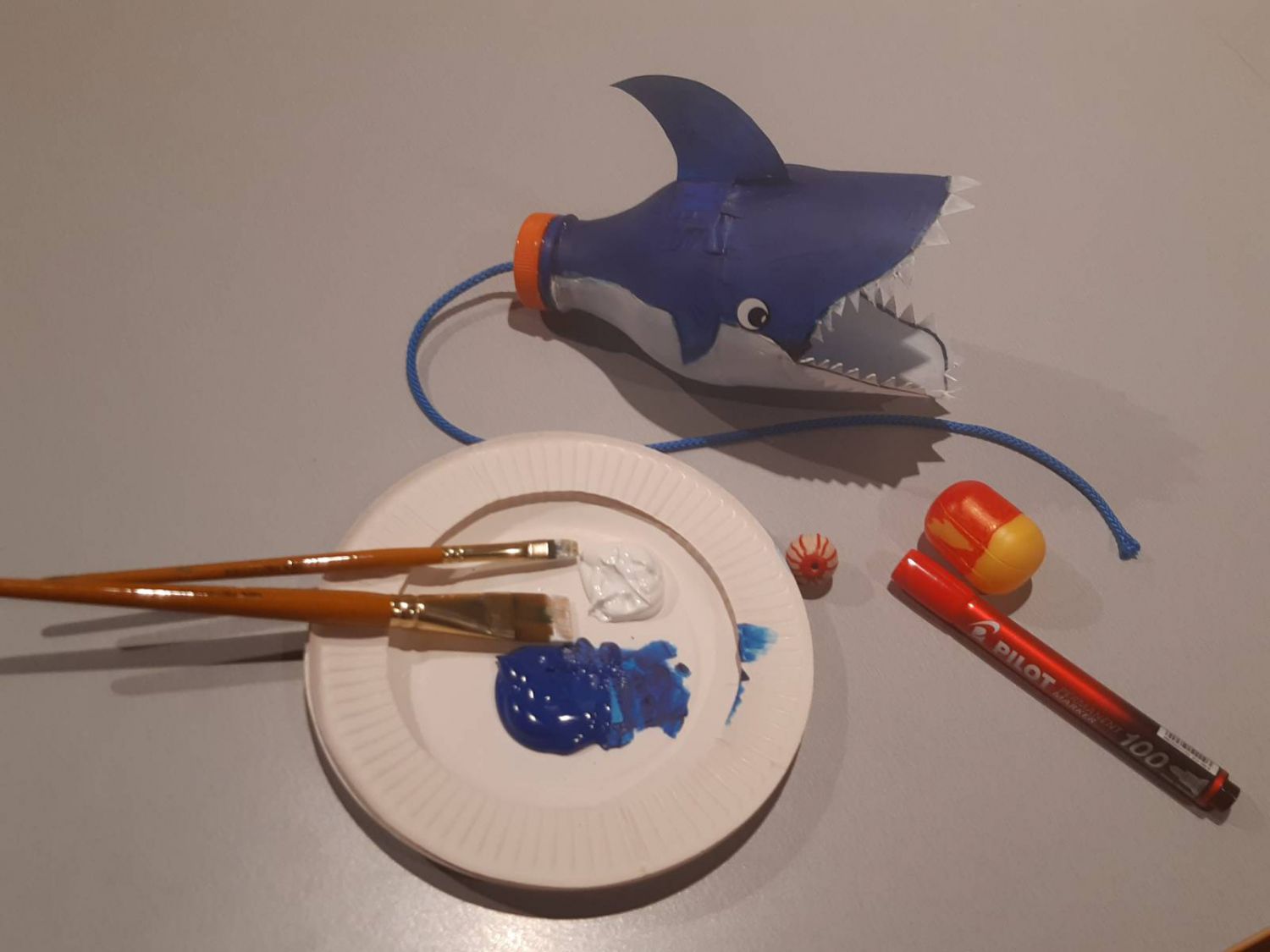selbstgebastelte Spielzeug aus alten PET-Flaschen die wie Haie bemalt sind 